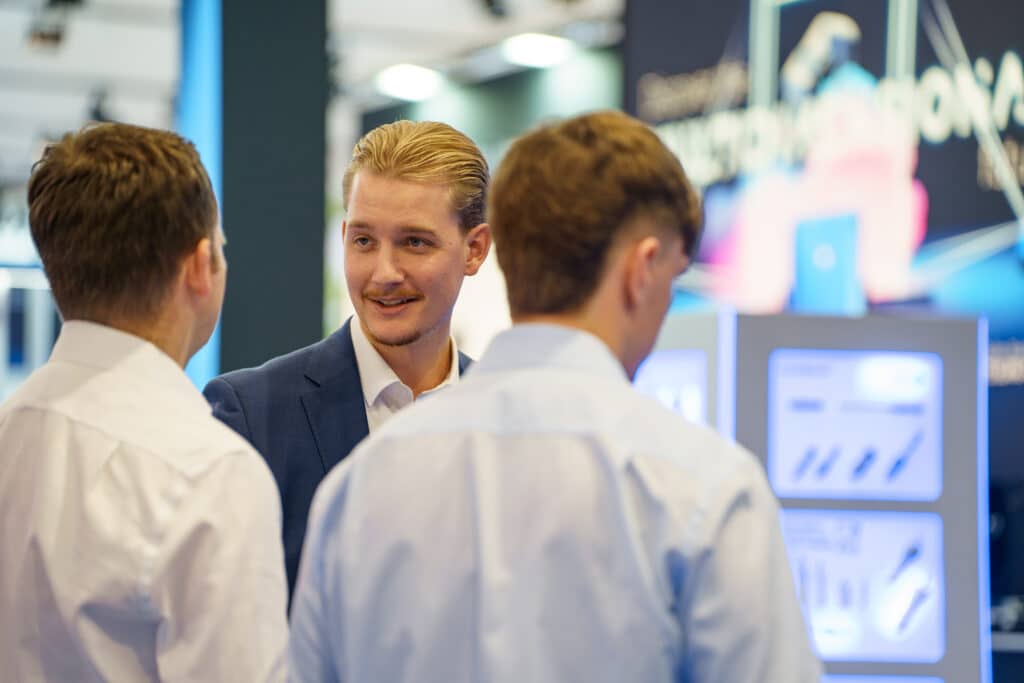 Messefilm-B2B Fachbesucher-Austausch Messestand-Szene Technologie-Displays Produktdemo-Station Eventdreh-Imagefilm Business-Kommunikation