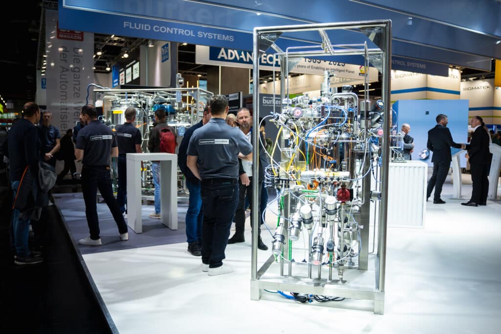 Messefilm-Industrieumgebung, Produktvideo-Anlagenbau, Fluid-Control-Systeme, Automatisierungstechnik-Exponat, Messestand-Aufnahme, Technik-Detailaufnahmen, B2B-Eventdoku