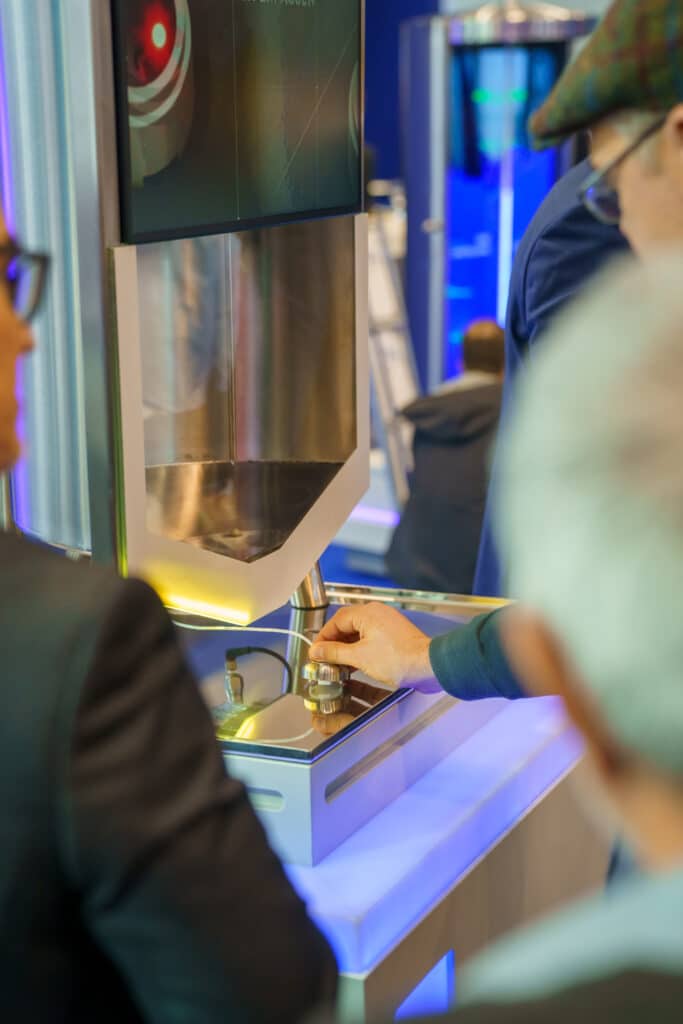 Messefilm-Industrie-Produktdemo-Bedienpult-Nahaufnahme-Hand-am-Drehknopf-Hightech-Maschine-Display-am-Stand-LED-Beleuchtung-Technik-Showcase