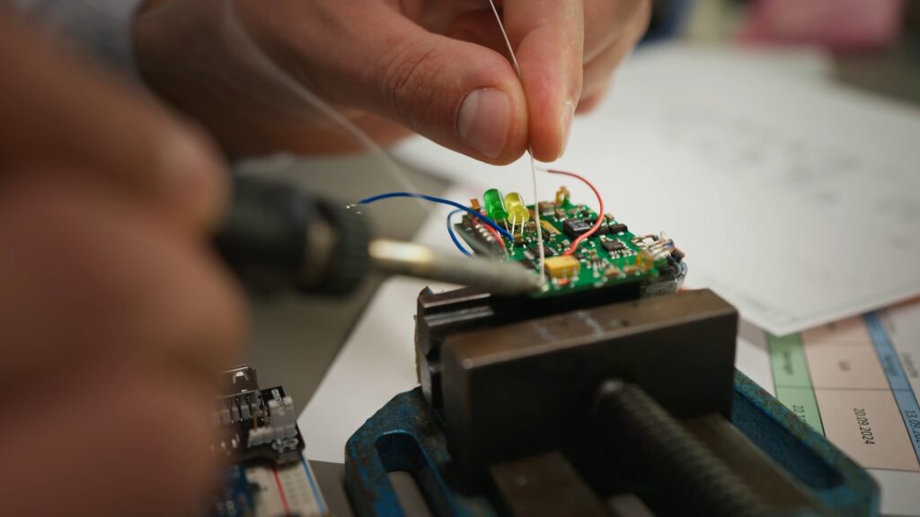Produktvideo-Elektronikfertigung Nahaufnahme-Lötarbeit Detailaufnahme-Platine Mikroelektronik-Prototyping Industrieumgebung-Werkbank Präzisionsarbeit-Schraubstock Technik-LED-Verkabelung
