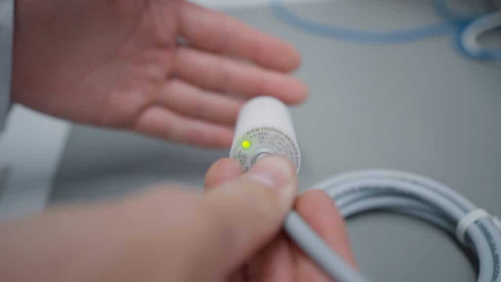 Produktvideo-Nahaufnahme Industrie-Sensor LED-Anzeige Hand-Interaktion Kabel-Verbindung Technik-Detail Qualitäts-Prüfung Labor-Umgebung Makro-Detail